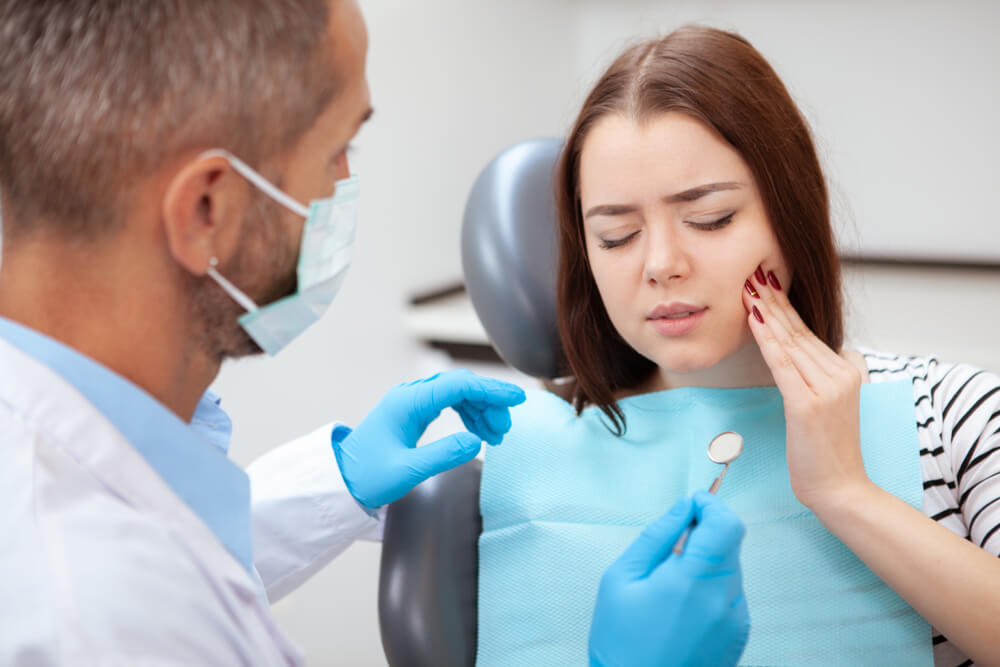 Young female patient holding her check at a dentist office