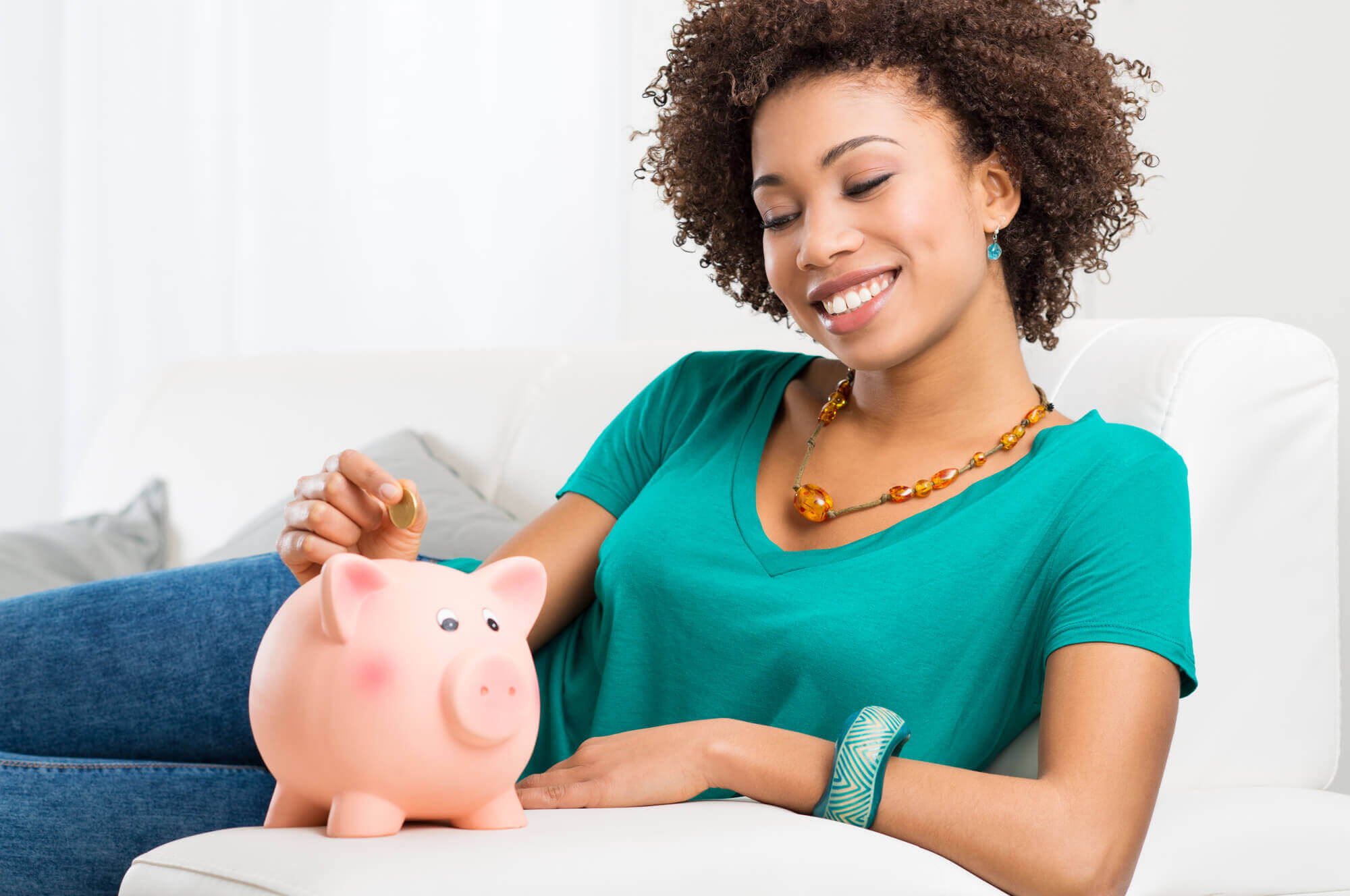 Young African-American female putting a coin in the piggy jar 2